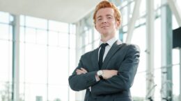 Young successful male manager of auto center waiting for new customers